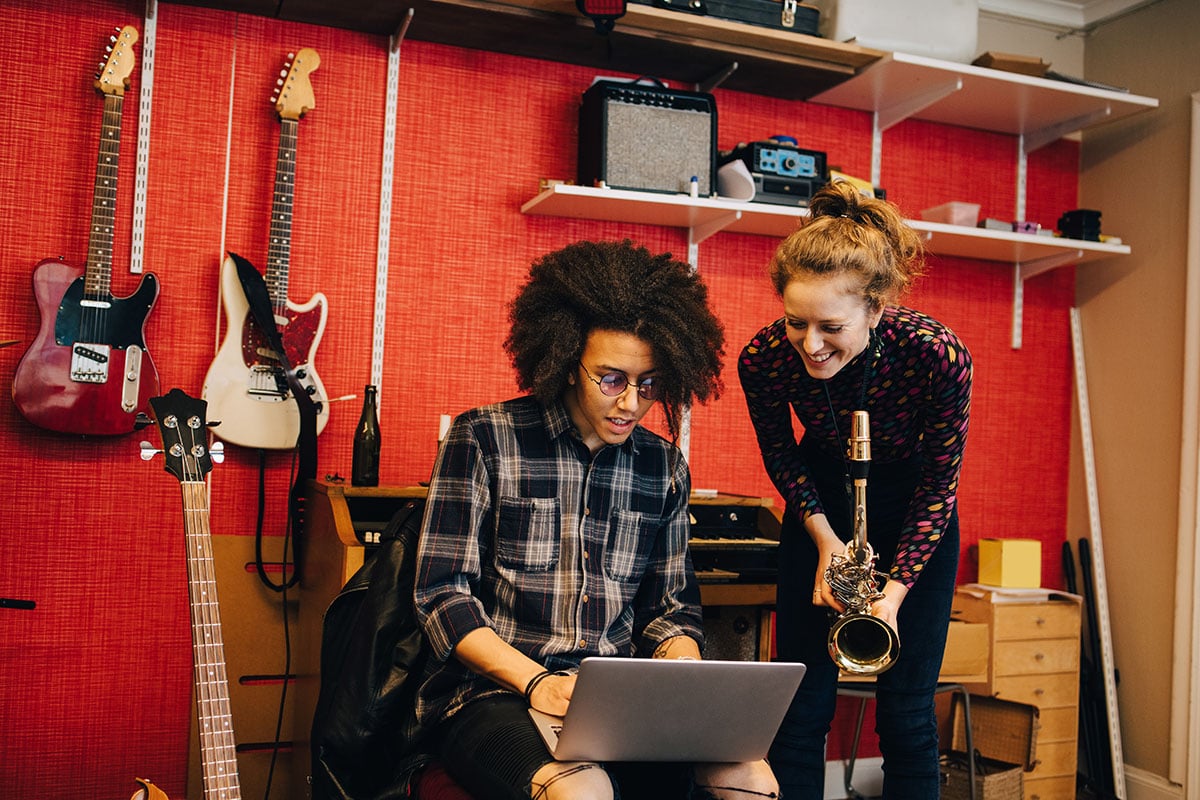 two musicians with a laptop in a music instrument shop