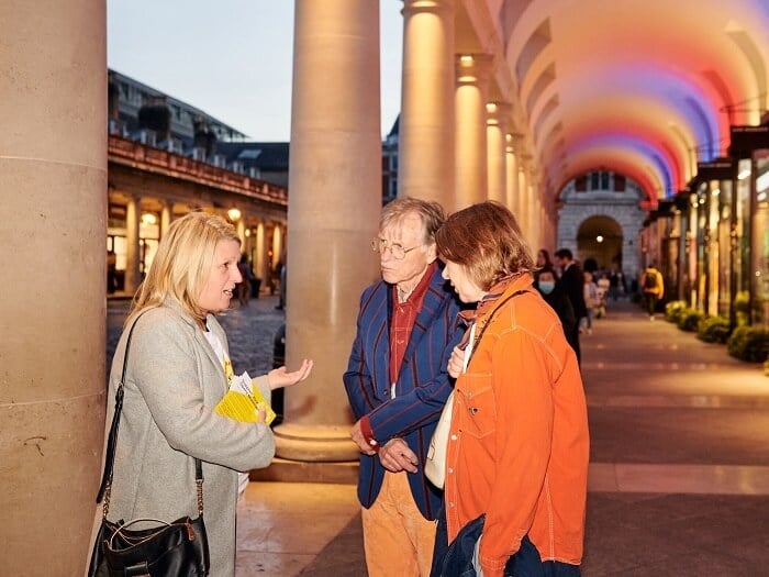 Naomi Pohl talks animatedly to two visitors to the Royal Opera House in Covent Garden