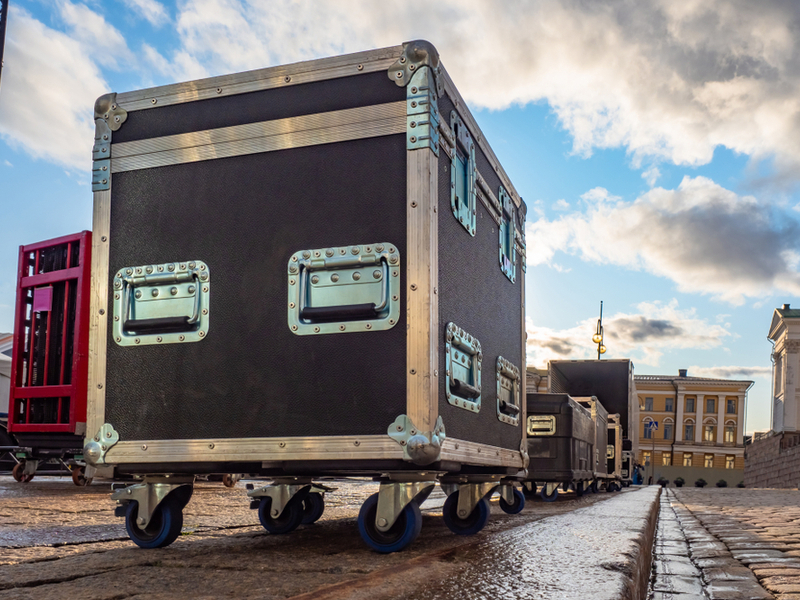 Photograph of a touring crate waiting to be transported on a rainy European street.